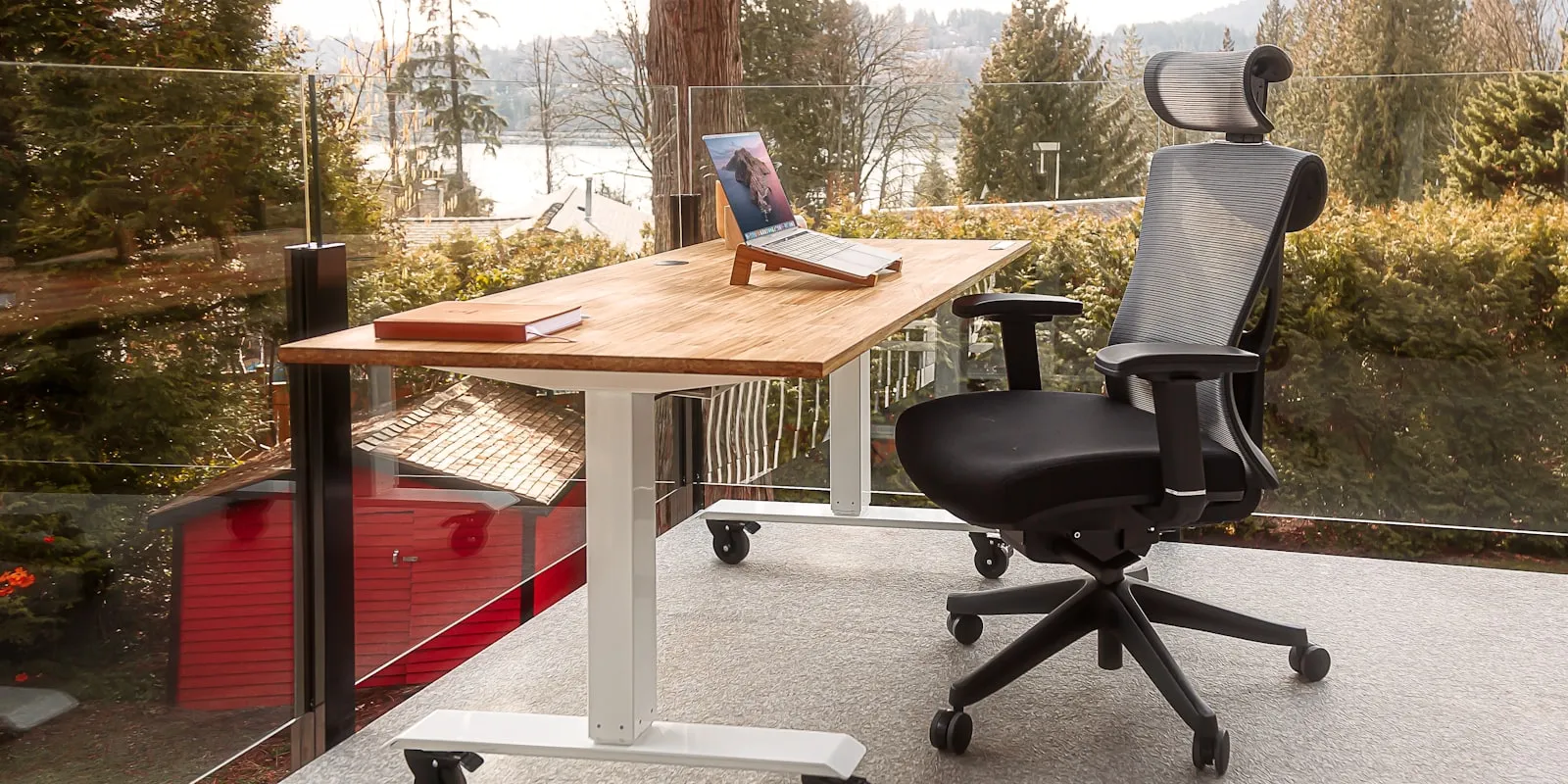 Bureau assis-debout électrique en position haute avec fauteuil ergonomique
