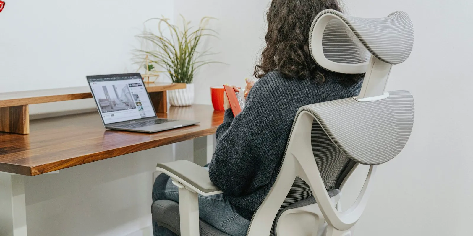 Personne assise, bas du dos soutenu contre le dossier d'une chaise ergonomique