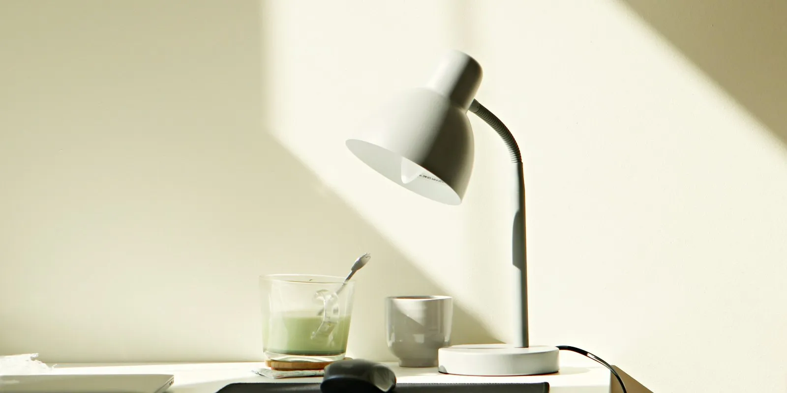 Lampe de bureau LED allumée sur un plan de travail clair