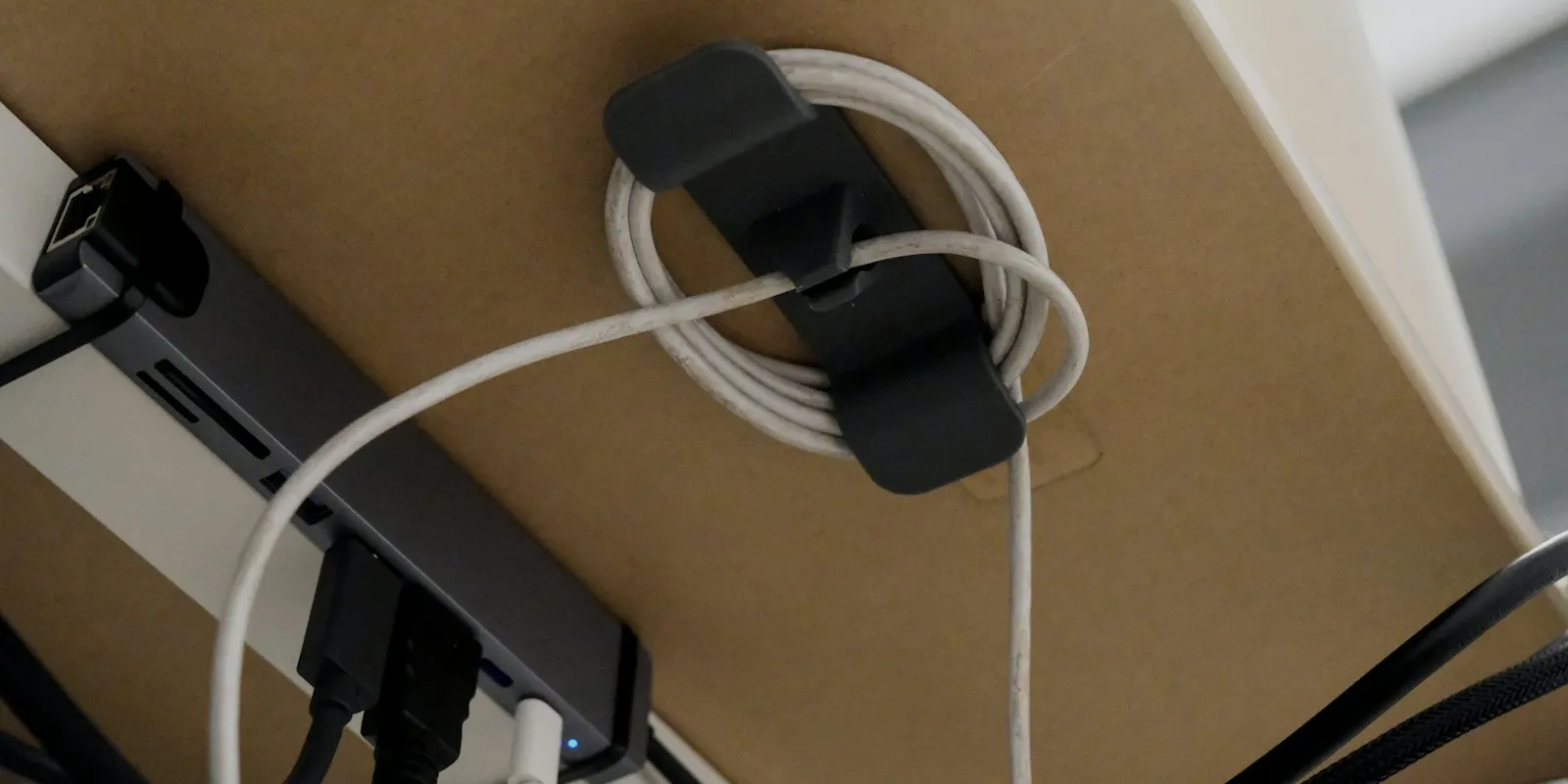 Câbles regroupés et rangés proprement sous un plateau de bureau